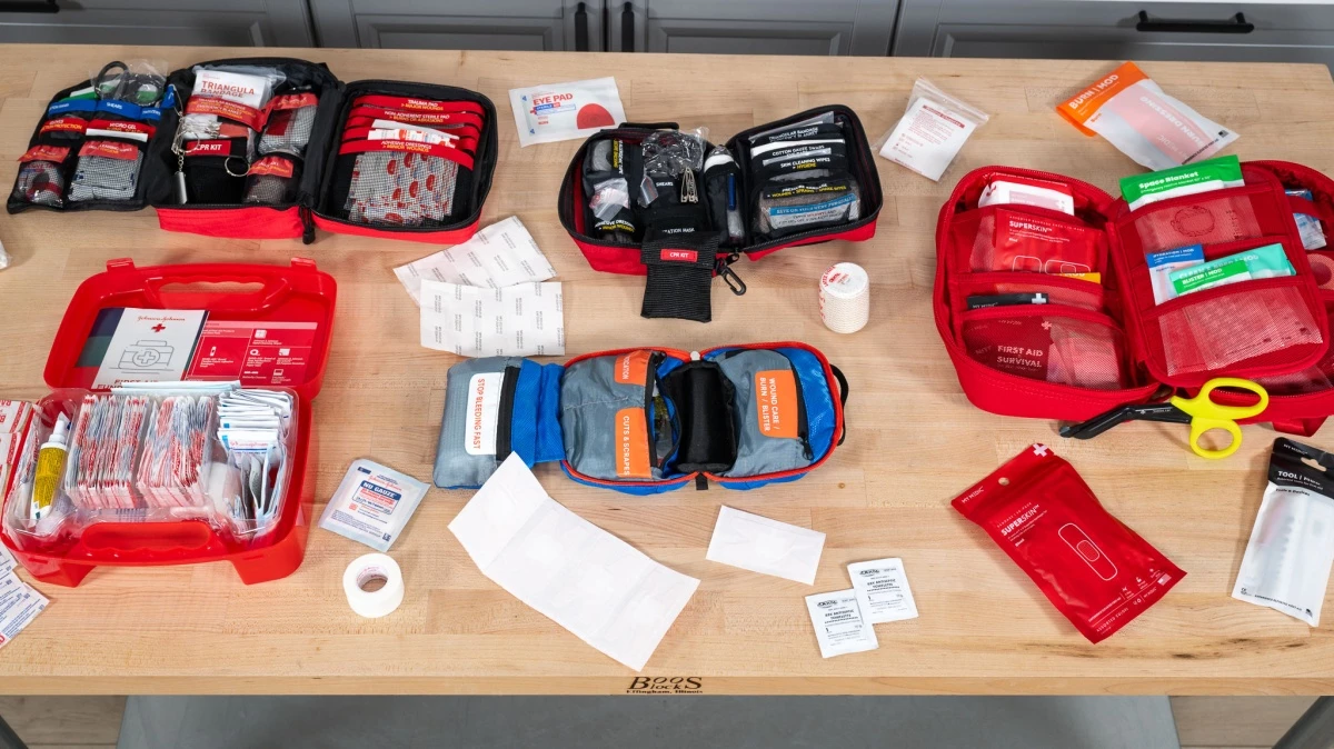 A wide variety of medical supplies including bandages, tapes, and tools spread out for a comparison review.