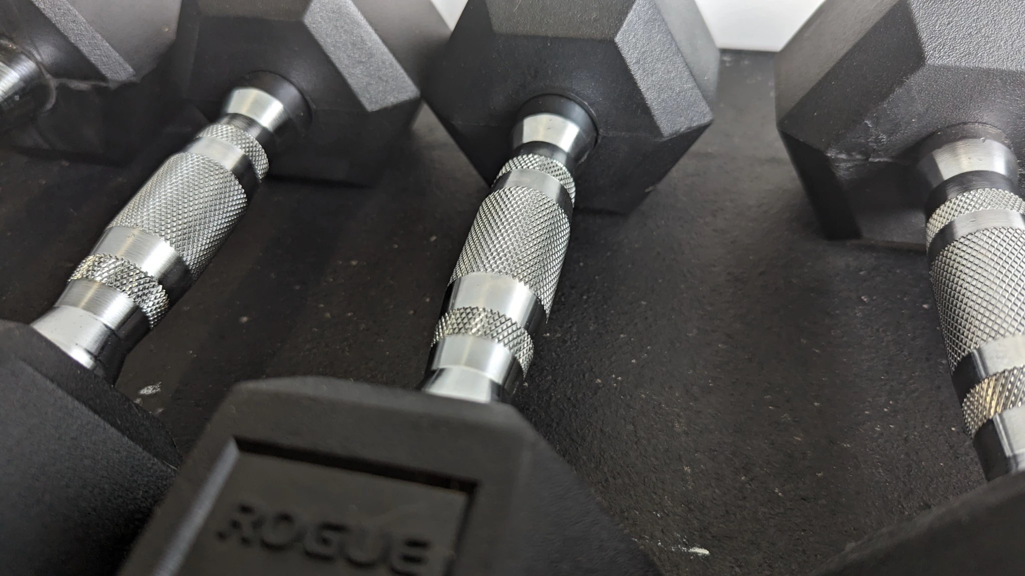 Close-up shot of the knurling texture on a high-quality steel dumbbell handle.