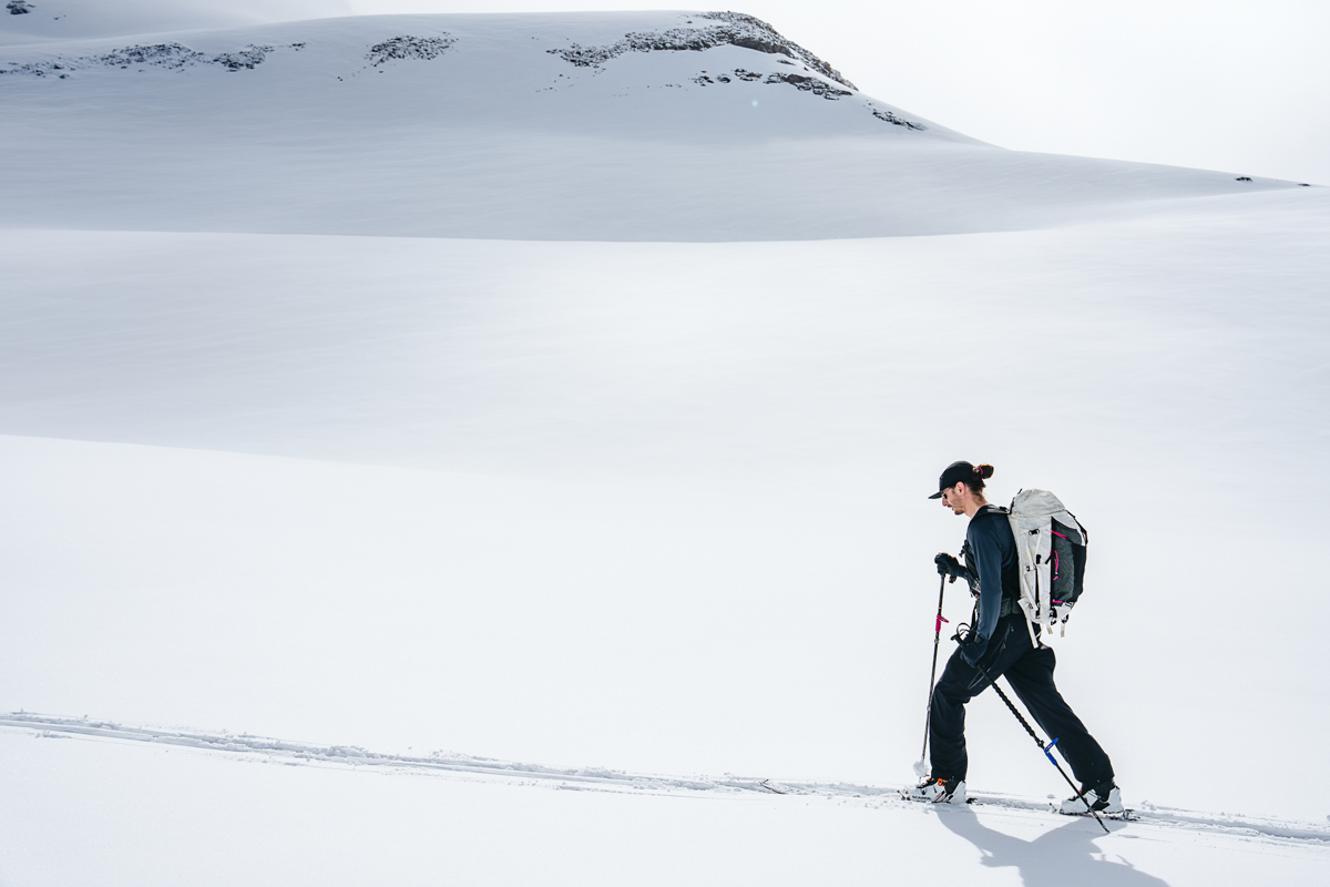 A man skinning uphill in a Patagonia Capilene Midweight Crew baselayer.