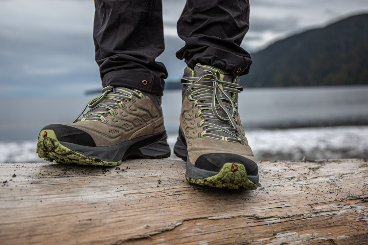 A pair of brown and green Scarpa Rush 2 Pro Mid waterproof hiking boots resting on a fallen log.
