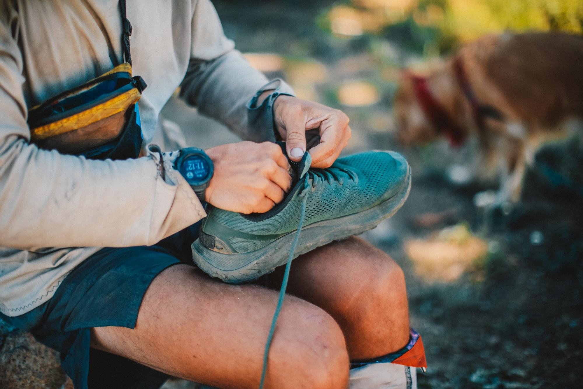 Hiker using trekking poles for stability and impact reduction on a mountain trail.