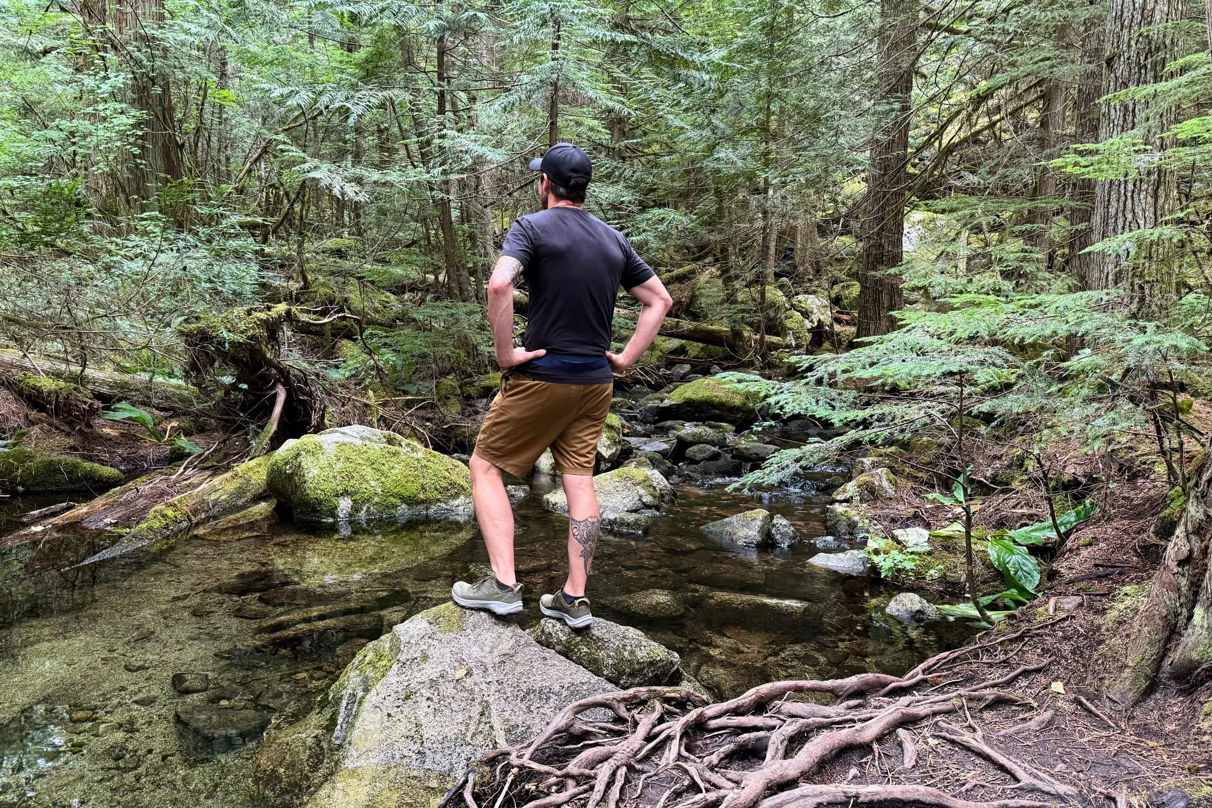 The North Face hiking boot stepping through a wet and muddy trail environment.