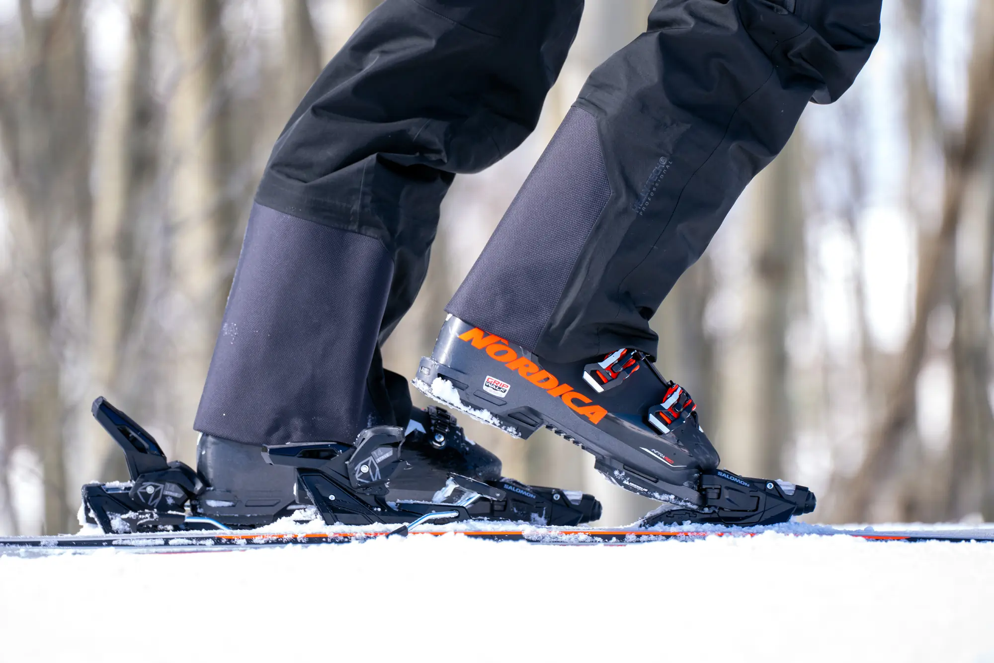 A close-up of a ski pant hem featuring reinforced scuff guards.