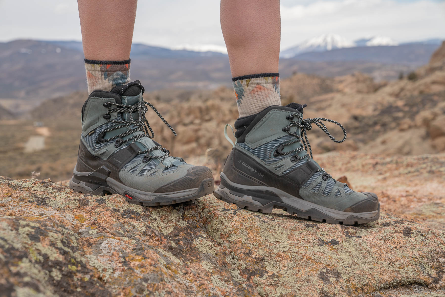Side profile of a Salomon Quest 4 GORE-TEX hiking boot on a rocky surface.