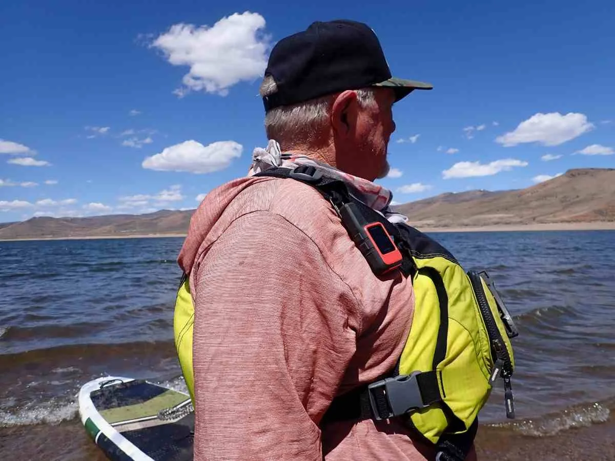 Garmin inReach Mini 2 clipped to the shoulder strap of a PFD during a paddleboarding session.