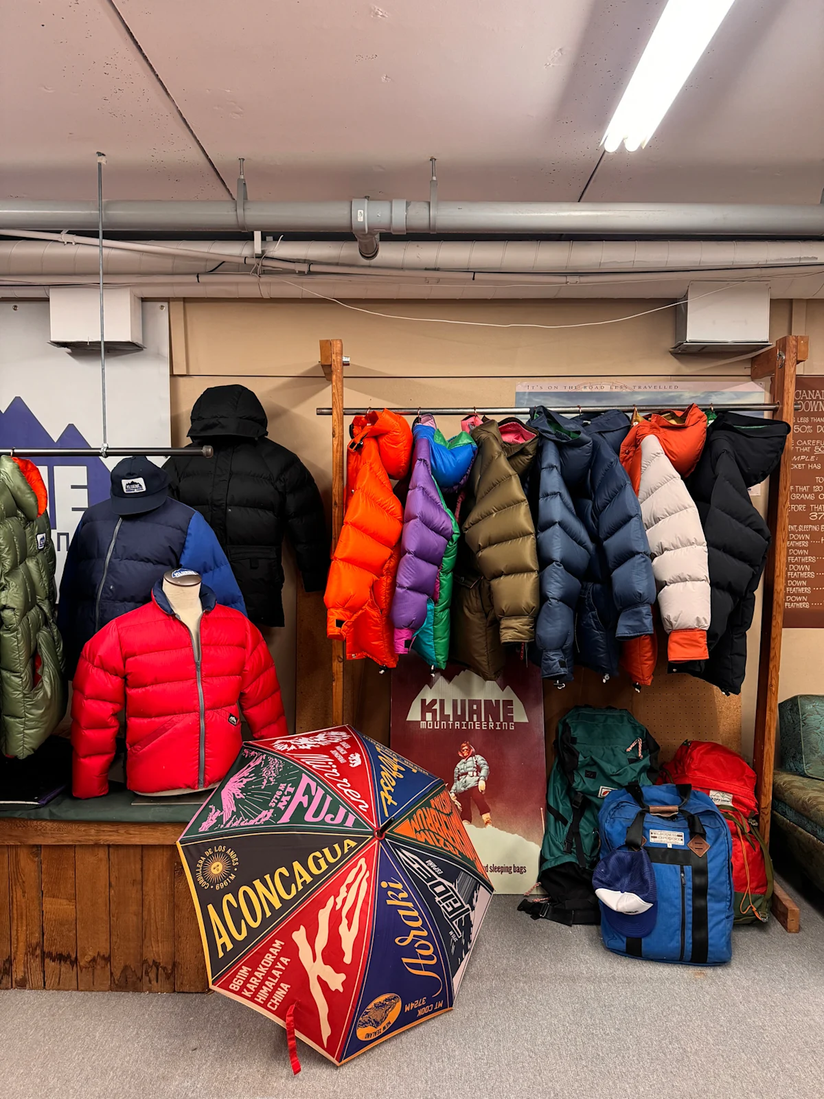 A row of colorful down parkas hanging inside a small-scale manufacturing shop.
