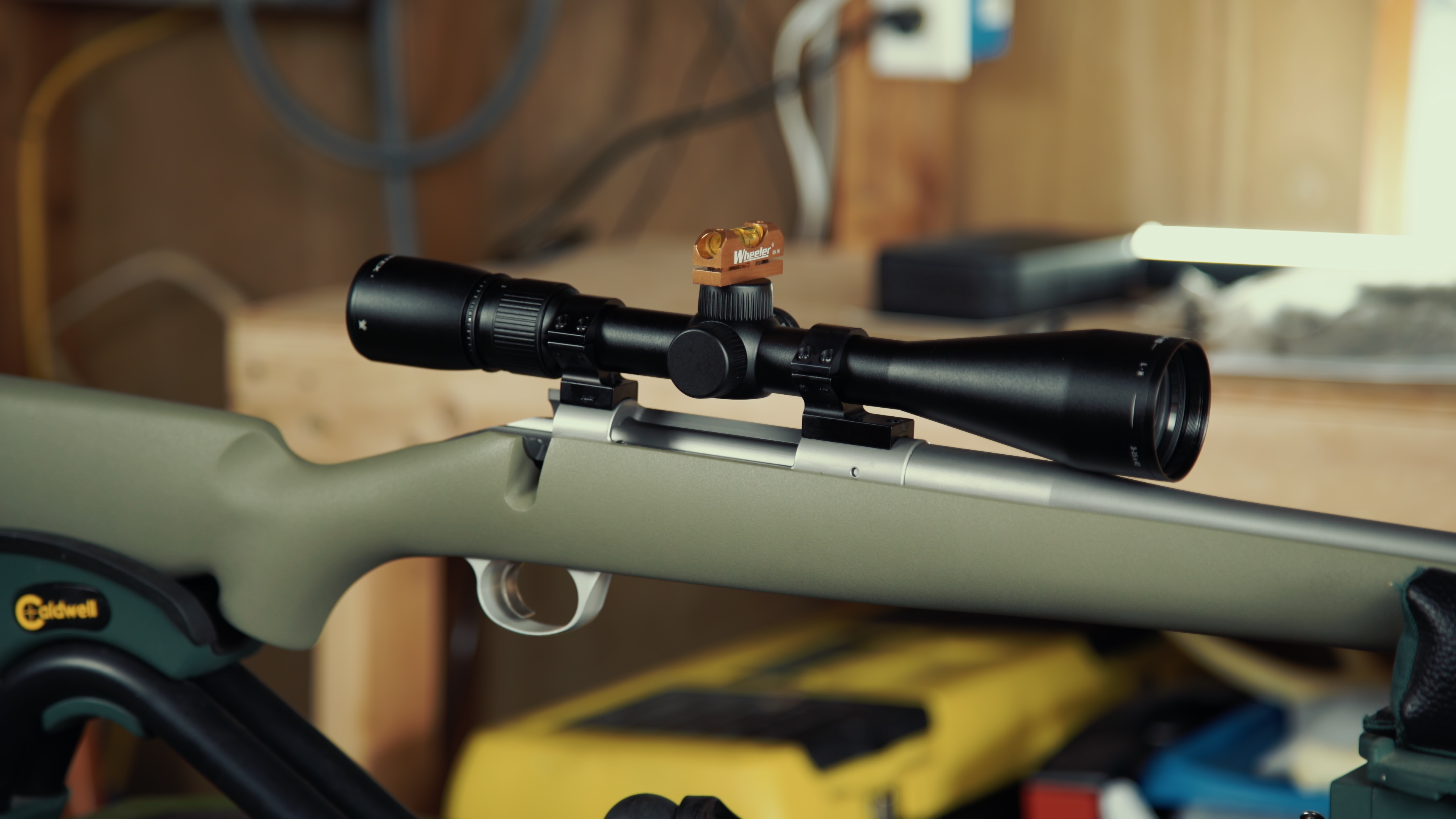 Technician preparing a Kimber Hunter rifle for the scope mounting process in a workshop setting.