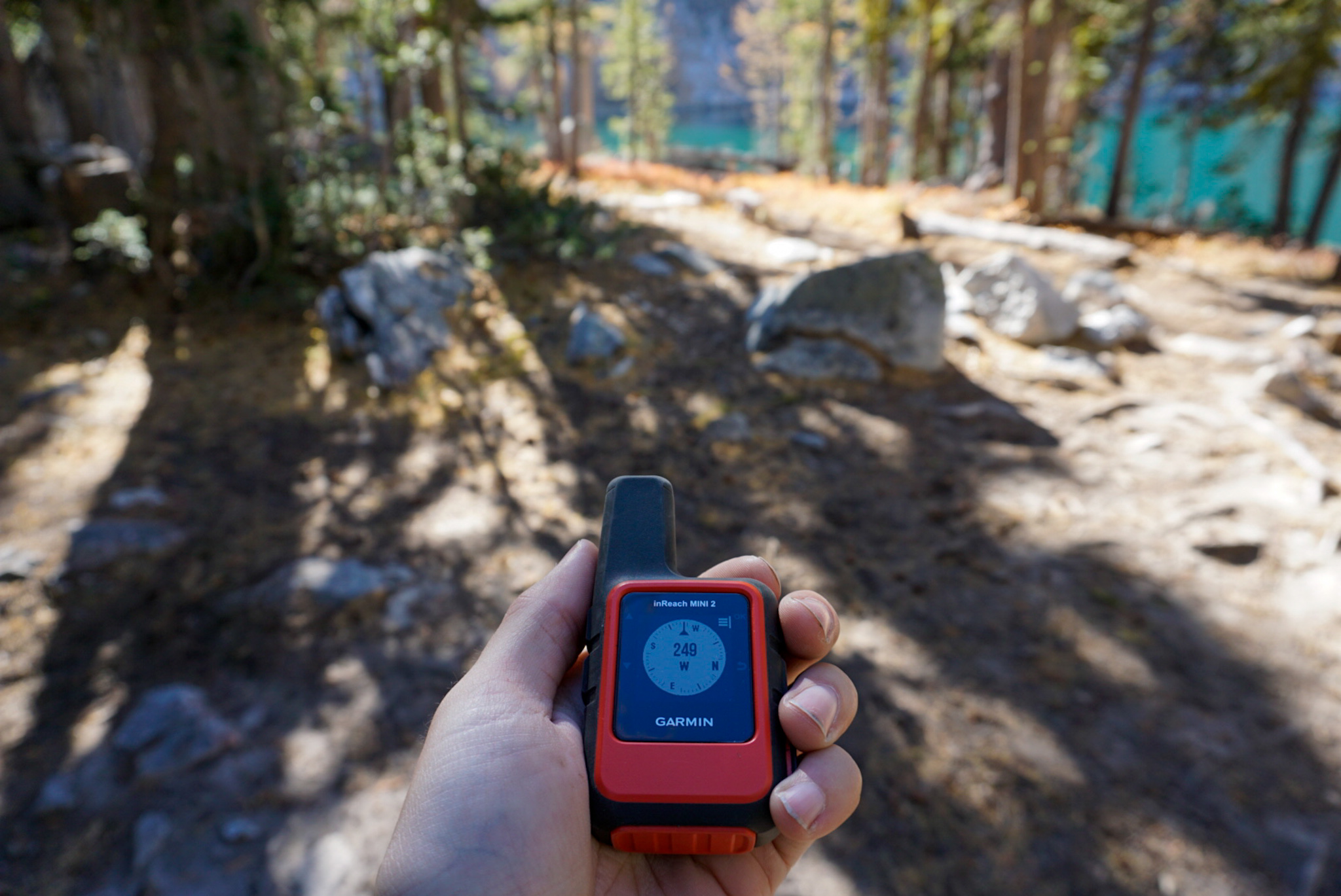 Close-up of a Garmin inReach Mini 2 handheld satellite communicator being used for navigation.