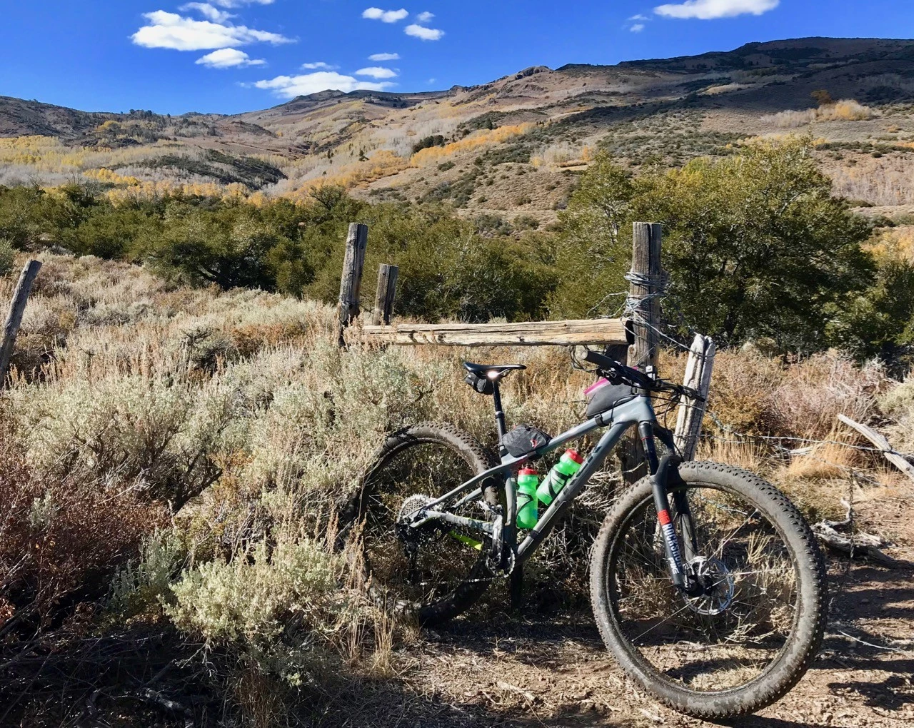 A mountain bike equipped with a top tube bag and an under-seat saddle bag for carrying tools and supplies.