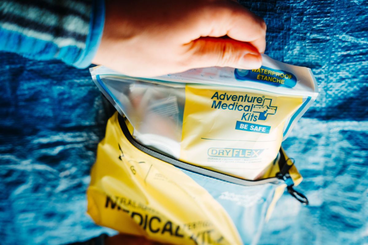 An Adventure Medical Kit featuring a bright yellow waterproof dry-bag style outer casing.