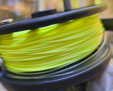 Coiled bright yellow floating fly line on a spool.