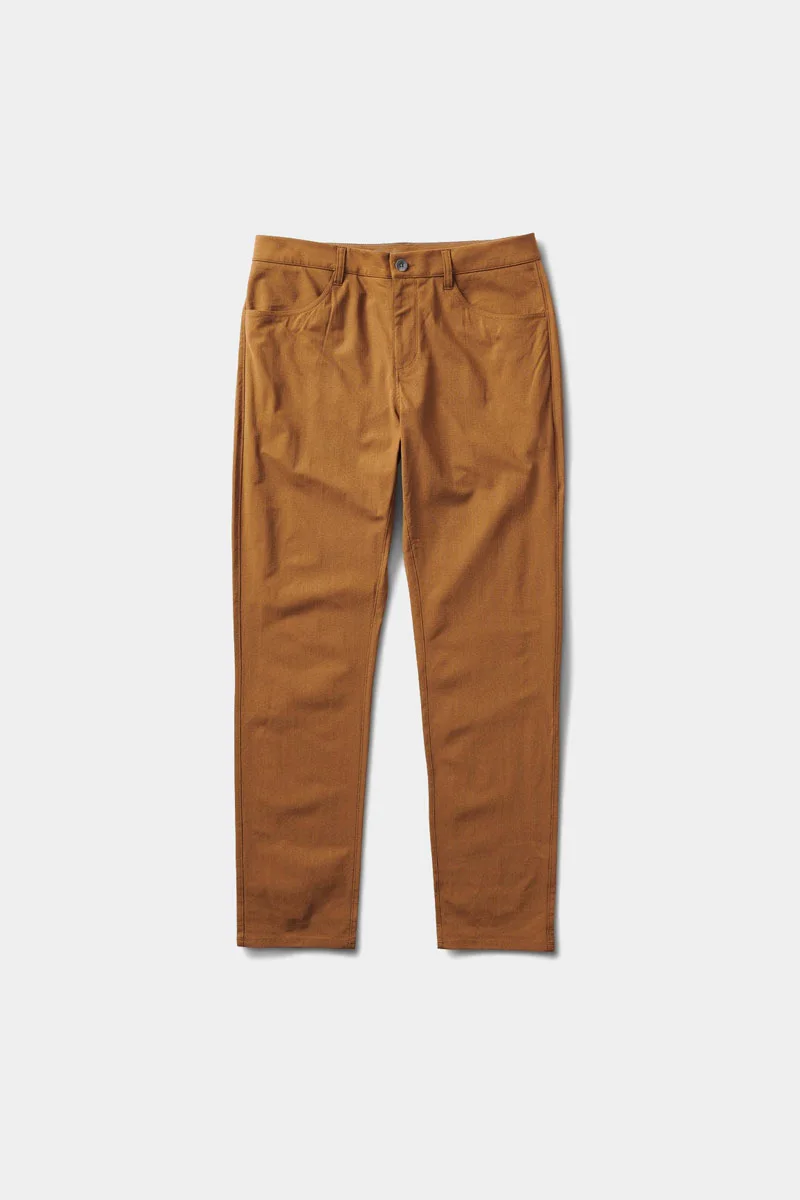 A person wearing Vuori Meta travel pants in a relaxed setting.