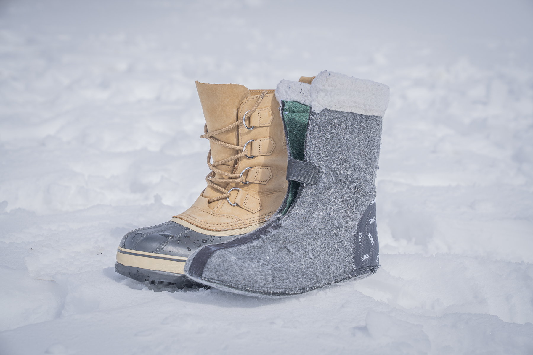 Detailed view of a Sorel Caribou boot illustrating the thick, removable felt liner partially pulled out.