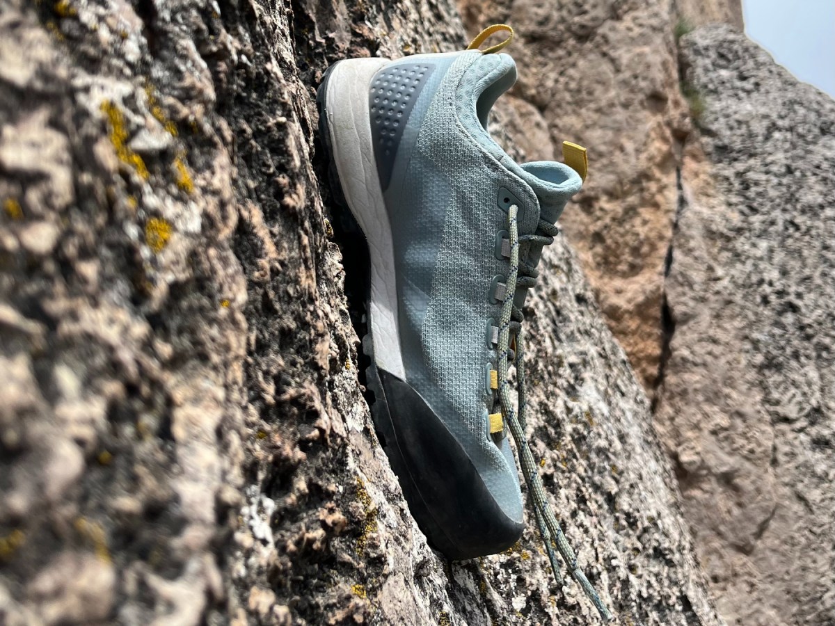 Macro shot of a shoe's rubber toe rand maintaining friction on a small rock edge.