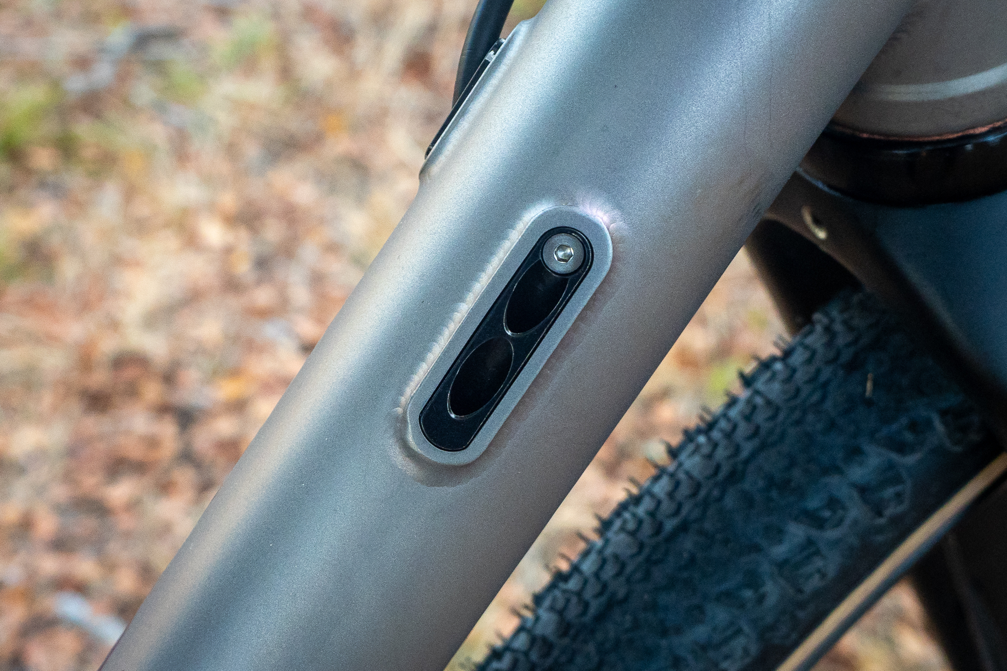 Detail shot of internal cable routing ports on a titanium bicycle frame.