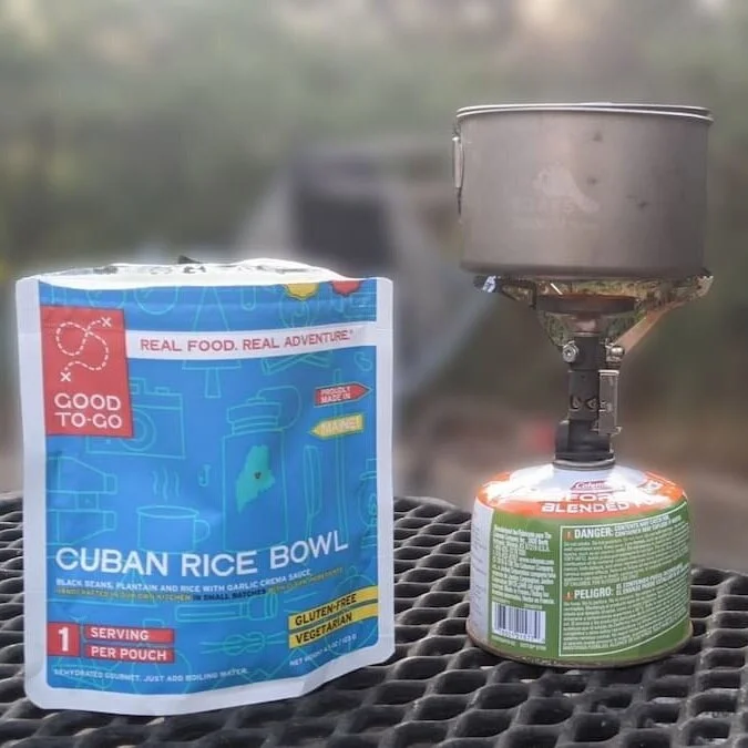 A backpacker preparing a meal on a camp stove at a hiker-biker site.