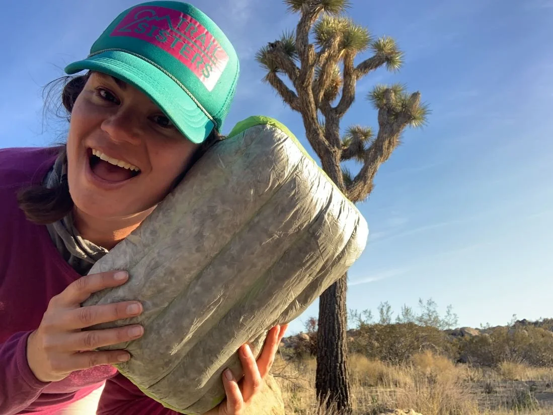 A gear tester laying on a camping pillow inside a tent while wearing a beanie.