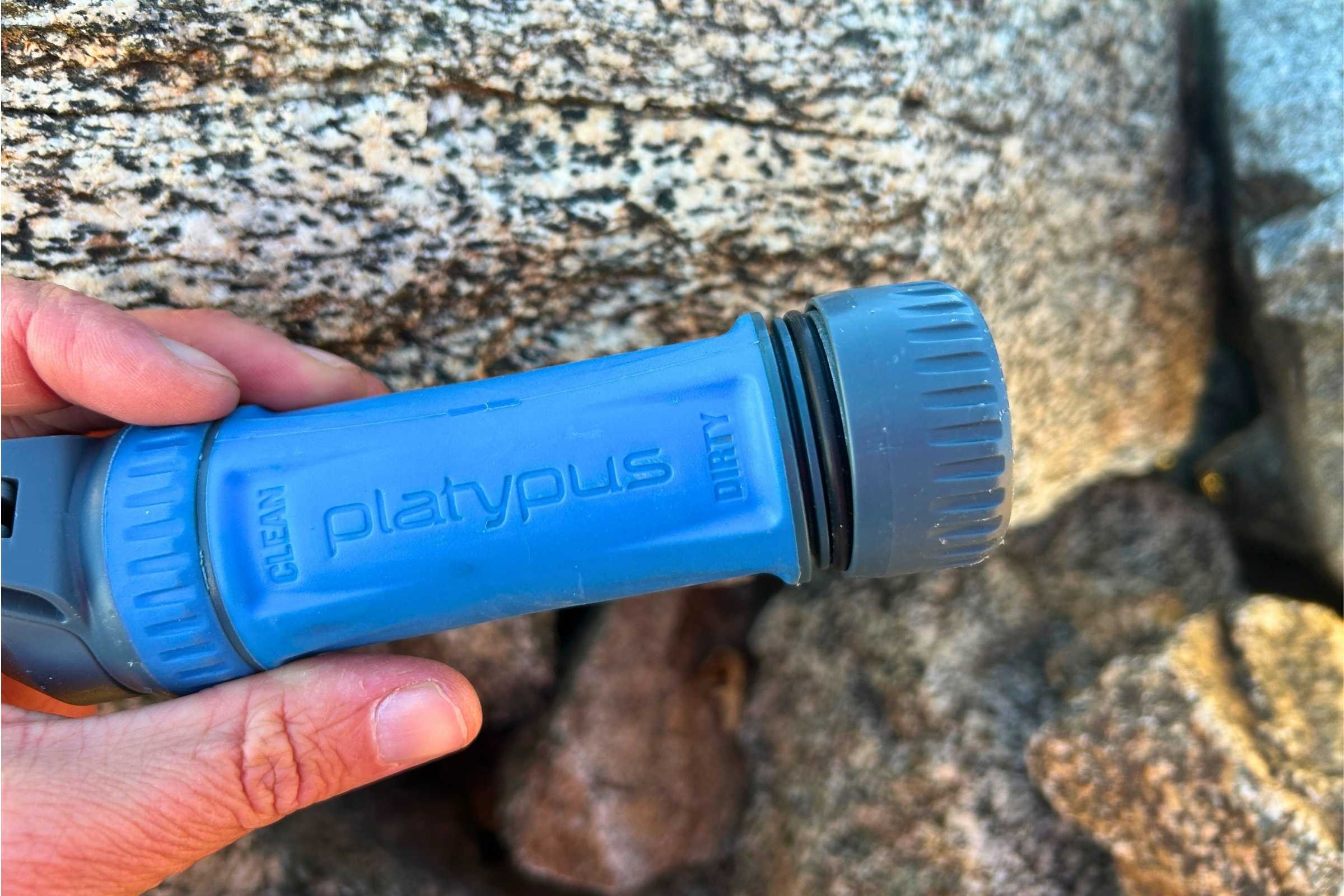 A Platypus Quickdraw water filter with its protective screw-on caps.
