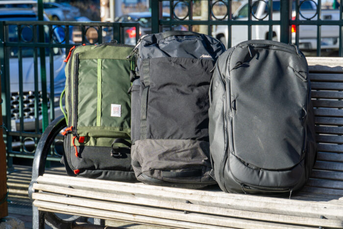 An array of different backpacks lined up side-by-side for a comparison review.