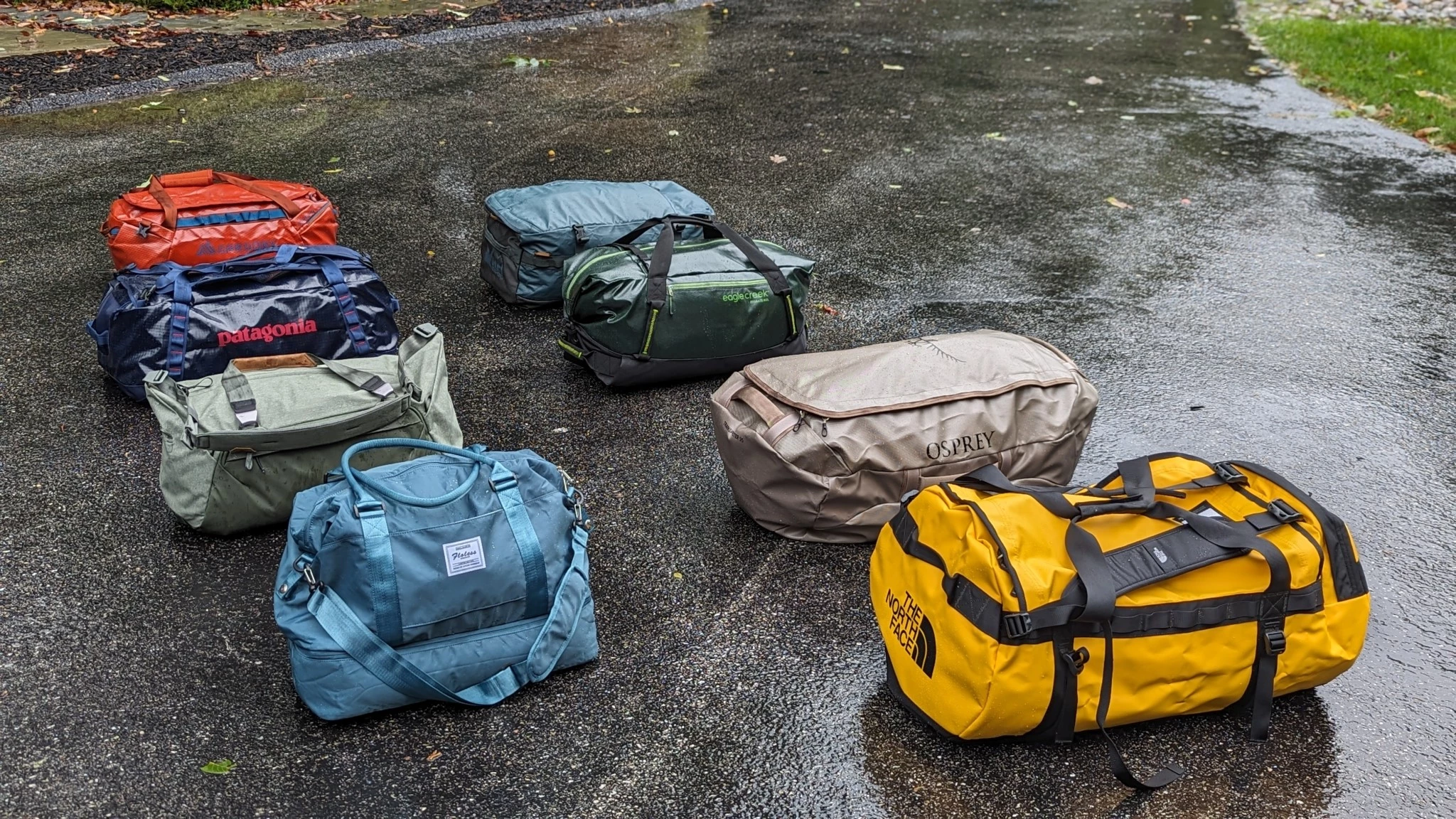 Multiple duffel bags of different sizes and styles lined up for comparison.