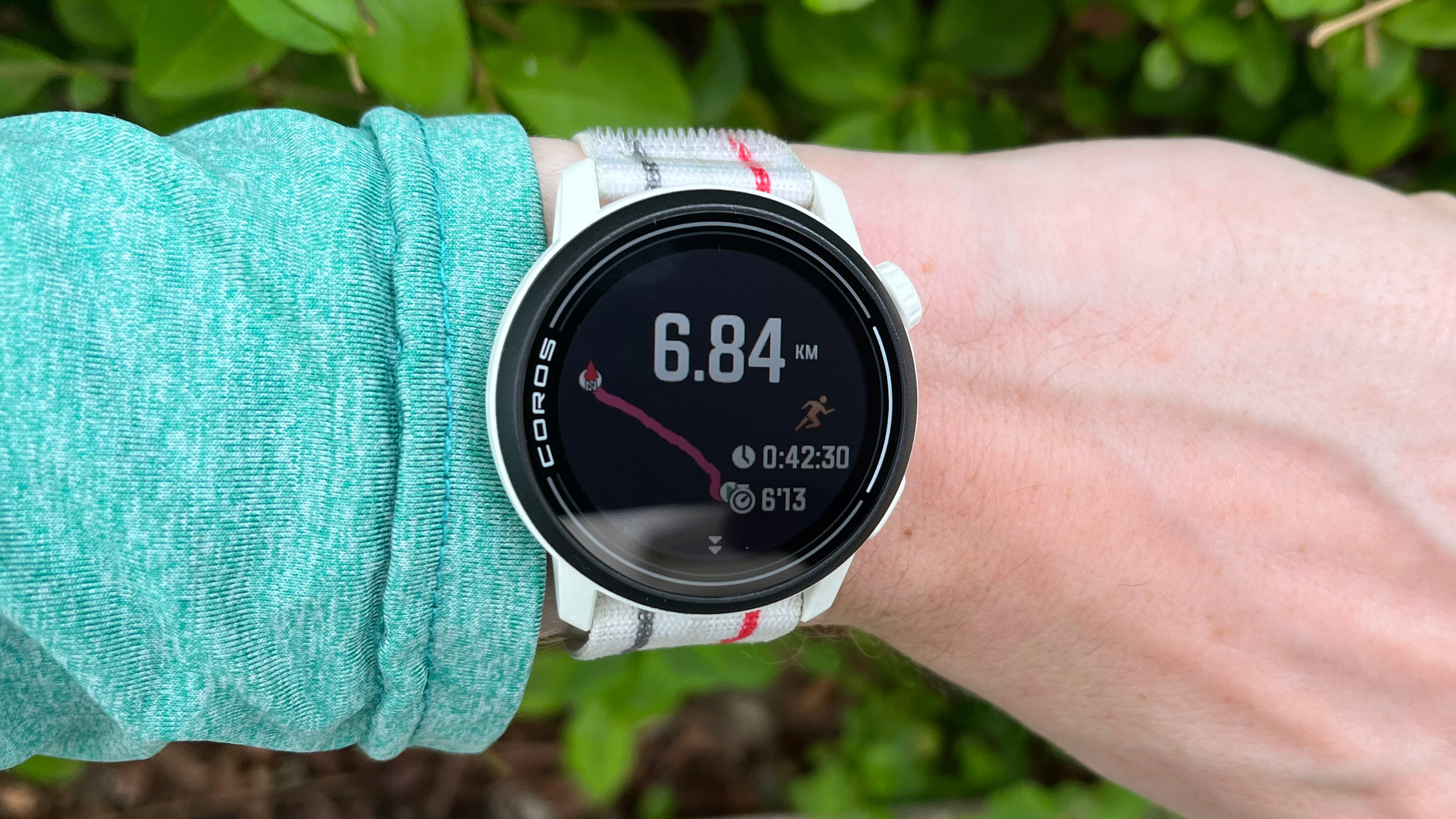 Coros Pace 3 white fitness watch with a nylon strap worn on a wrist.