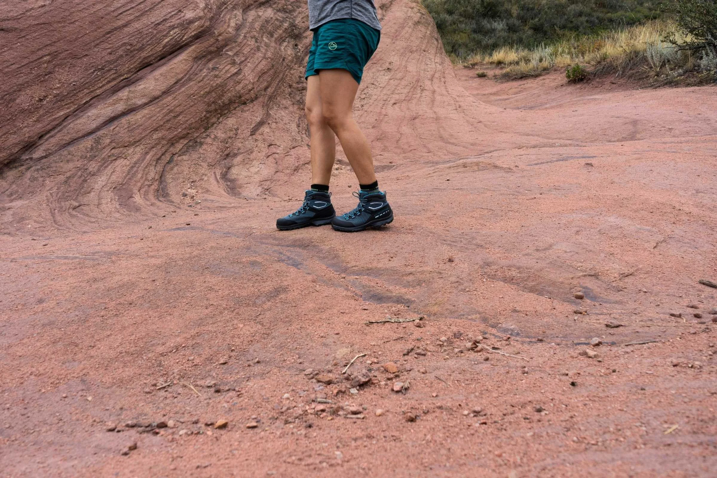 The La Sportiva TX Hike boot stepping on a wet, mossy rock and root system.