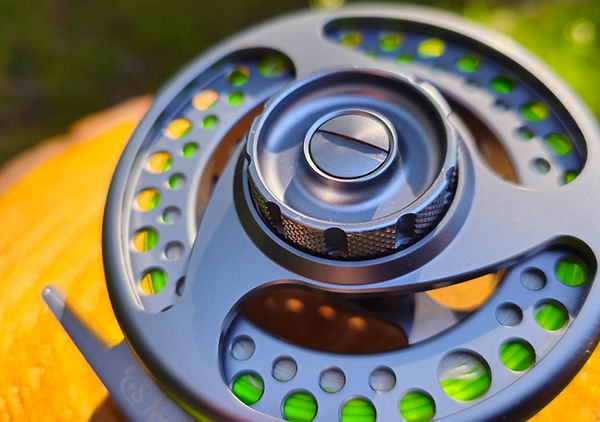 Macro shot of a modern fly reel drag adjustment knob and housing.