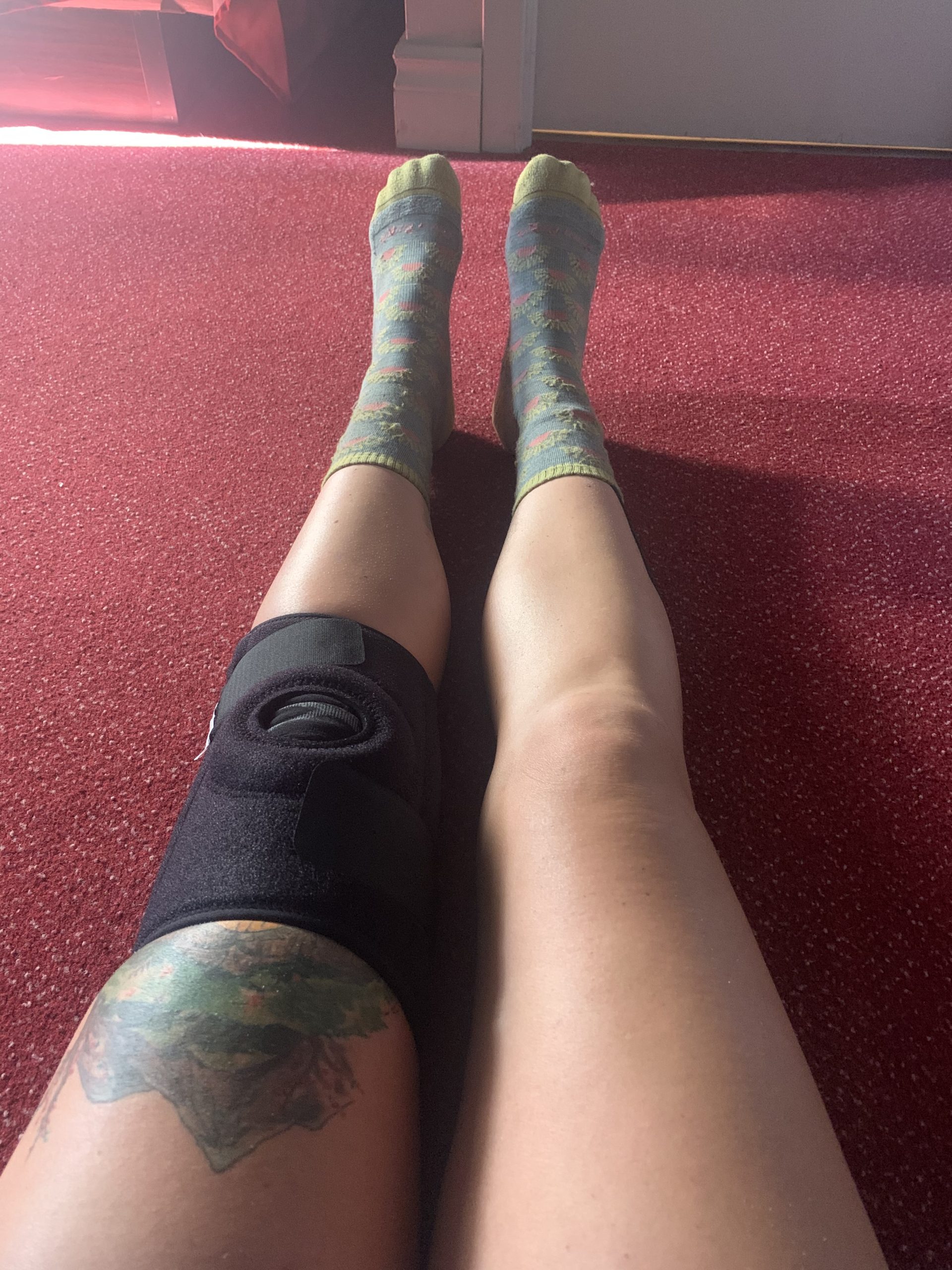Close-up of a leg wearing a professional brace for tendonitis support.