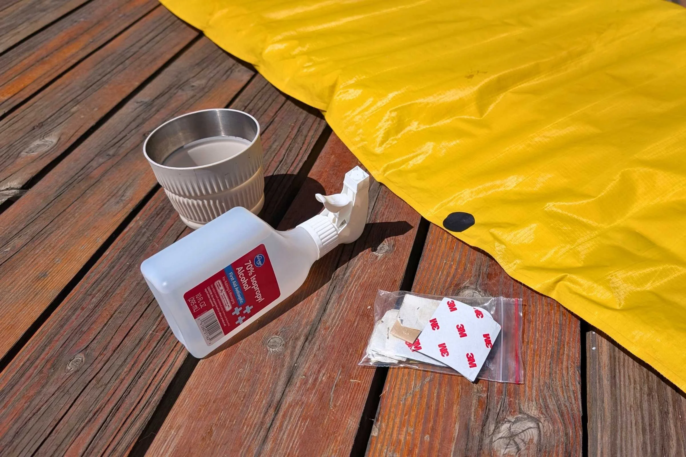 An assortment of repair tools including alcohol wipes, adhesive patches, and a permanent marker.