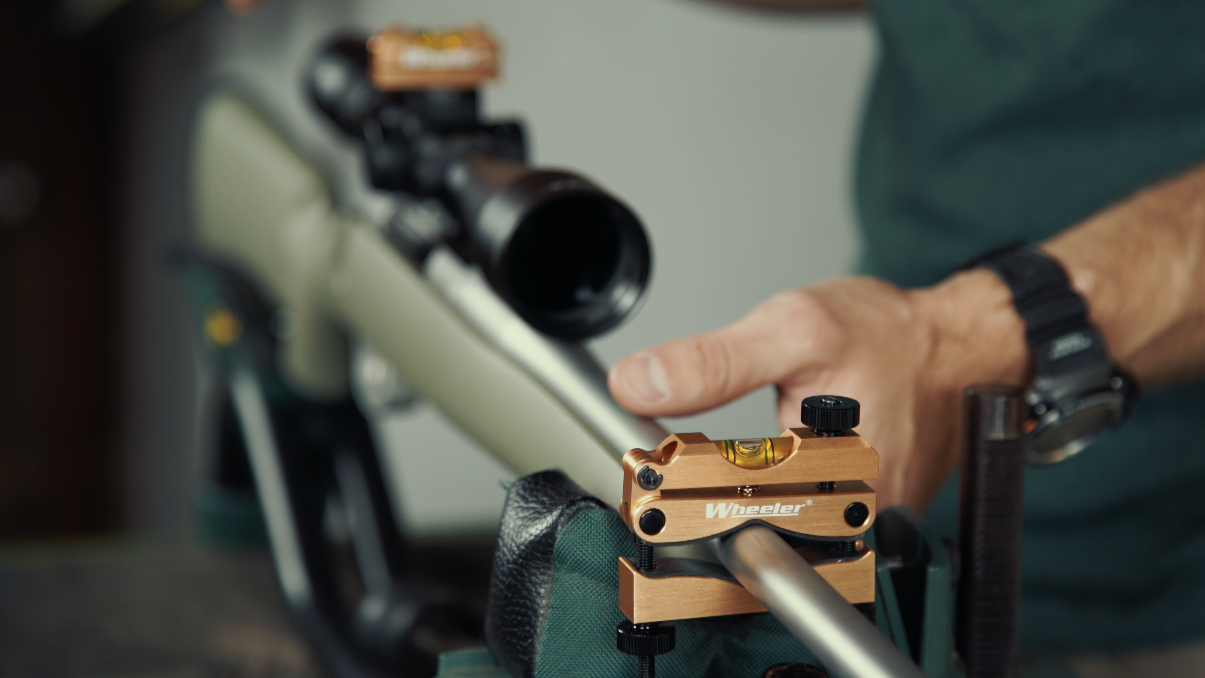 Close-up of a bubble spirit level sitting on top of a rifle scope turret cap to verify the horizontal plane.