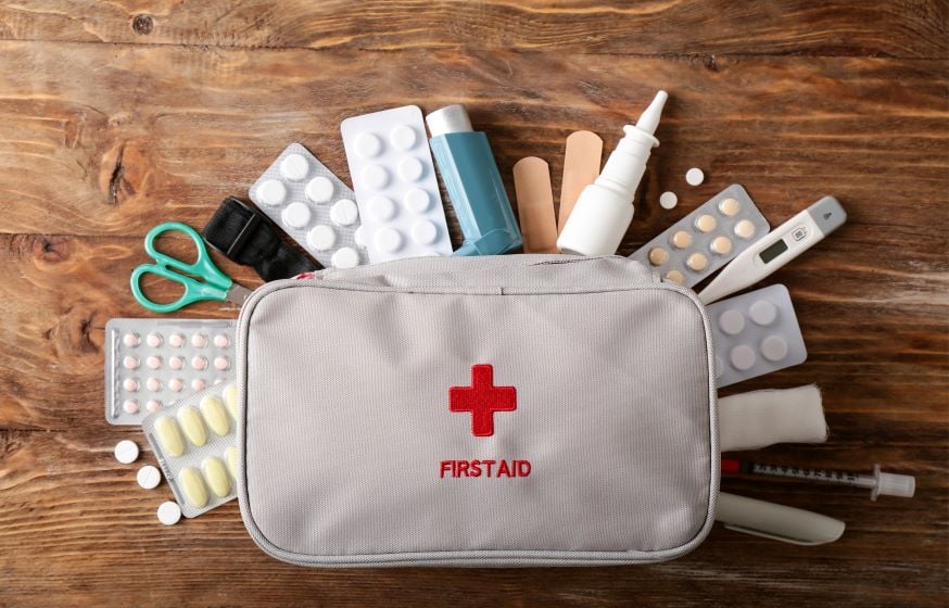 A variety of medical supplies including bandages, tape, and antiseptic laid out on a flat surface.
