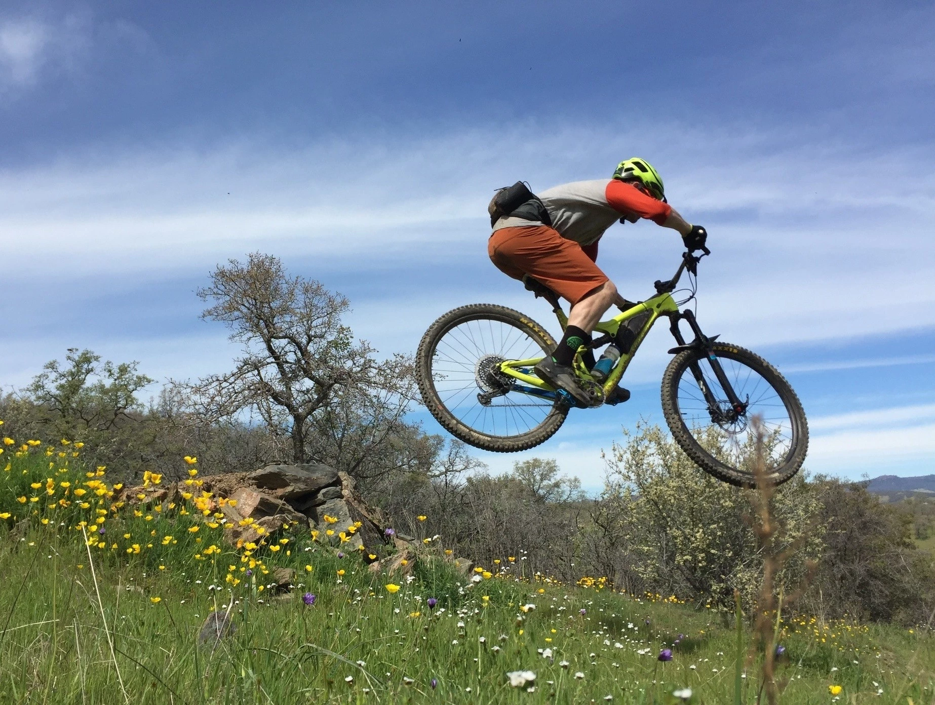 A mountain biker riding through scenic coastal trails during a product testing session.