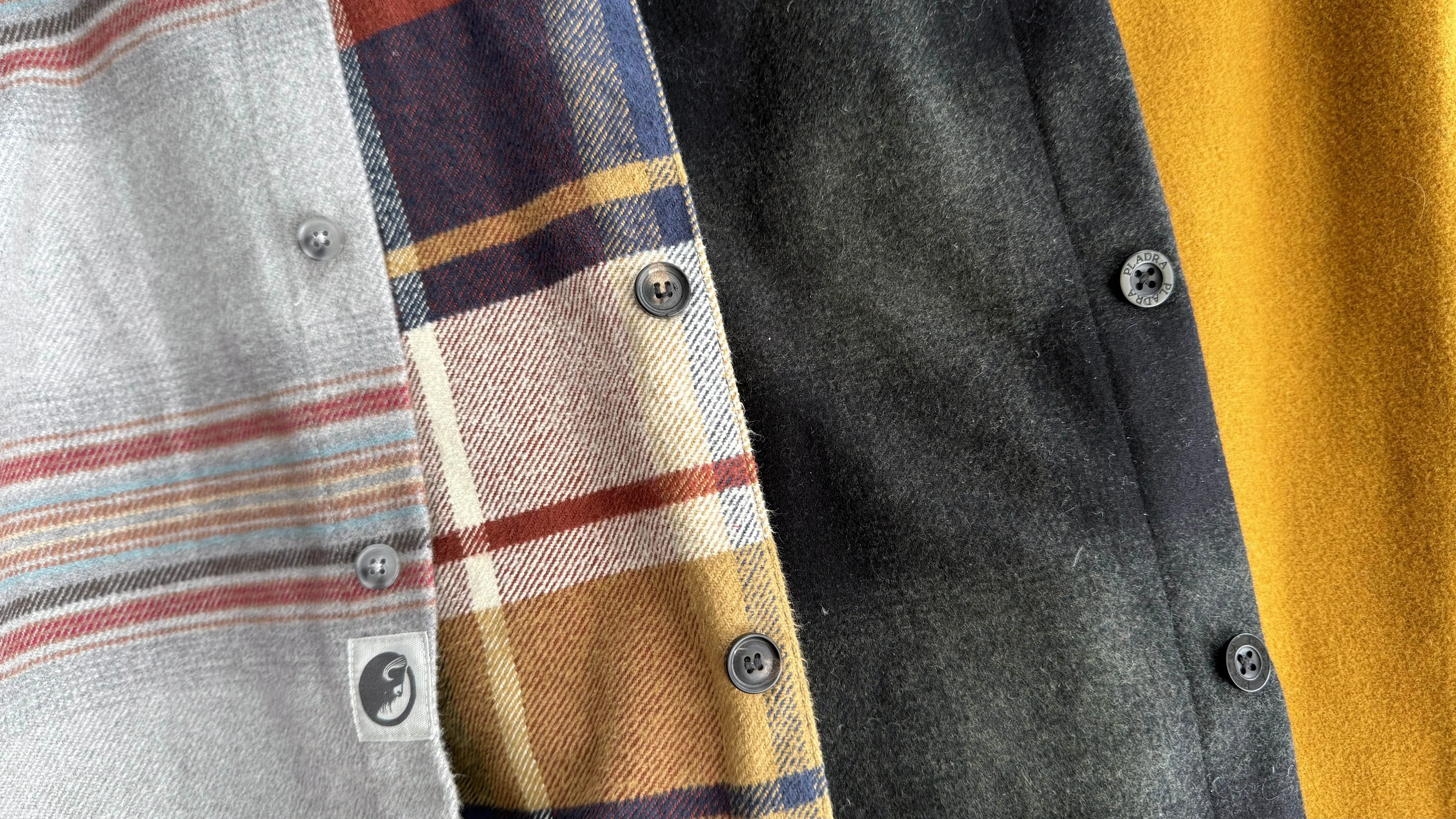 Four different flannel shirts compared side-by-side to show varying fabric weights from 278 to 400+ GSM.