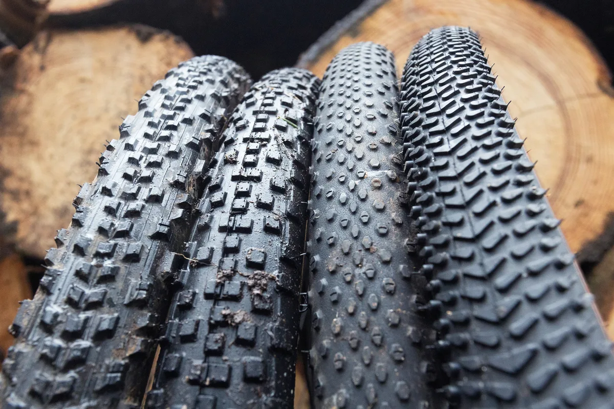 Four different types of gravel bike tires with varying tread patterns.
