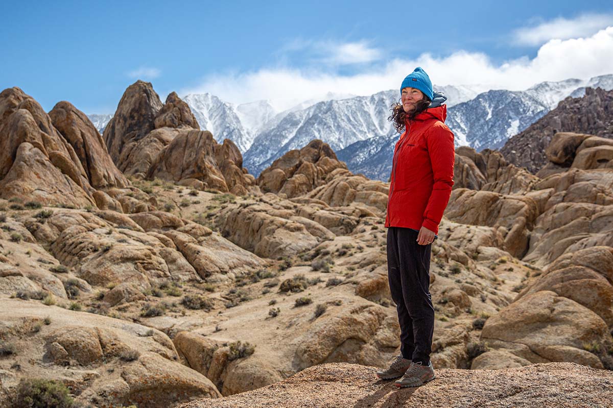 A woman wearing a gray Patagonia M10 Storm Jacket on a mountain ridge.