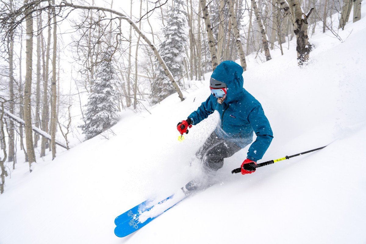 A skier navigating a high-alpine mountain ridge during gear testing.