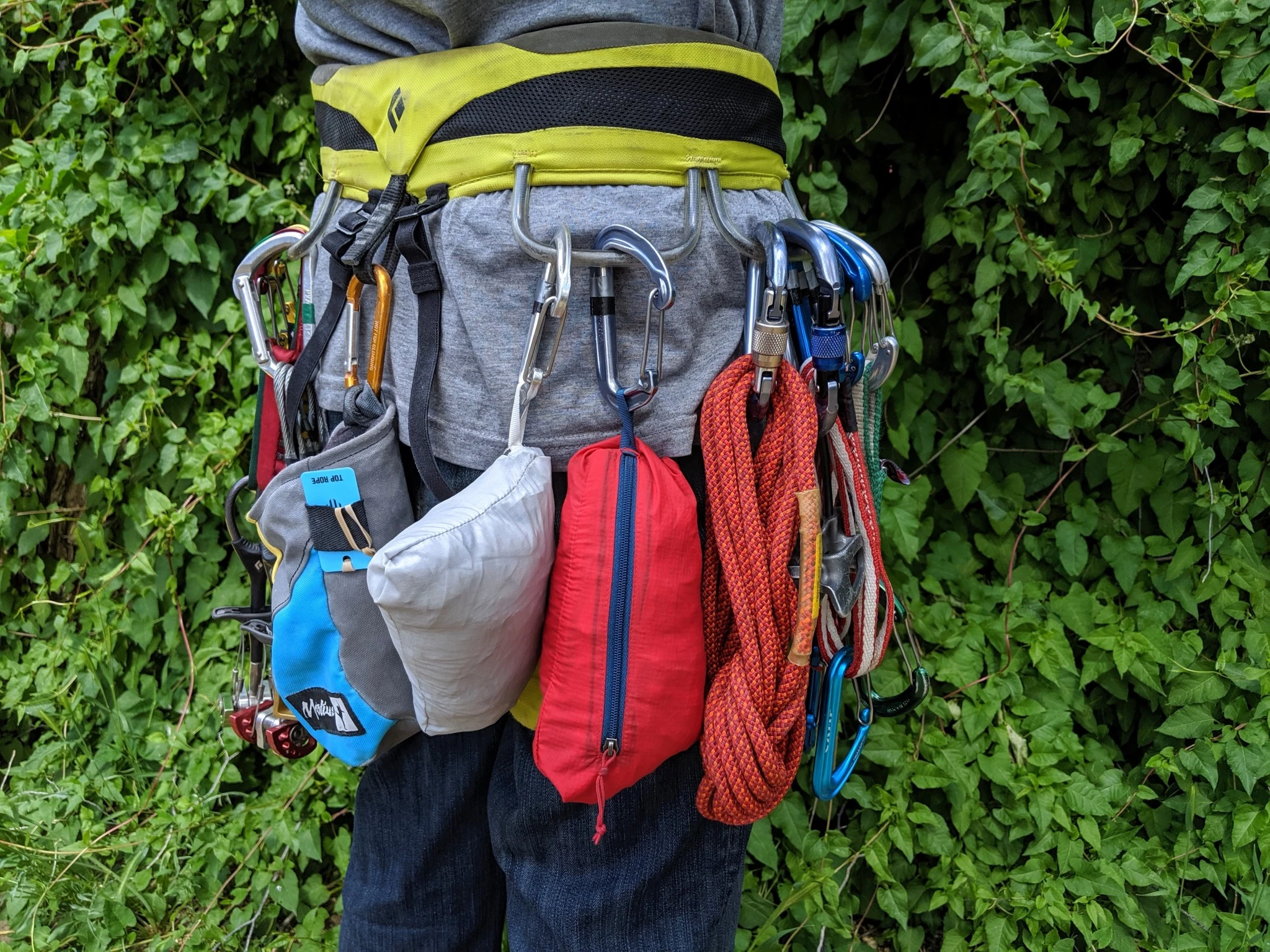 Two ultralight windbreaker jackets, the Black Diamond Distance and Patagonia Houdini, clipped to a climbing harness.