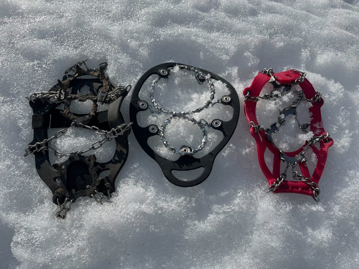 An outdoor expert testing traction devices in deep snow and cold conditions.