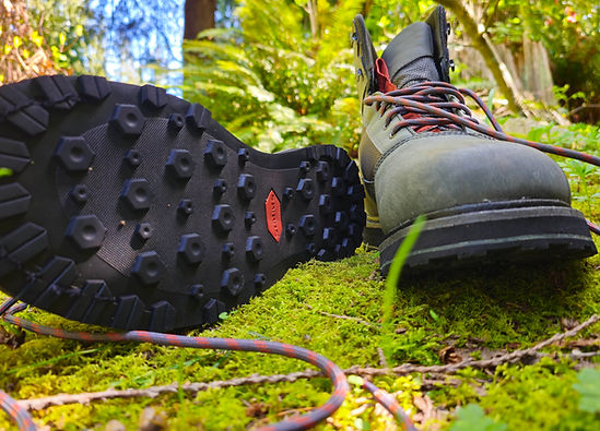 Product shot of a sturdy fly fishing wading boot with a specialized rubber traction sole.