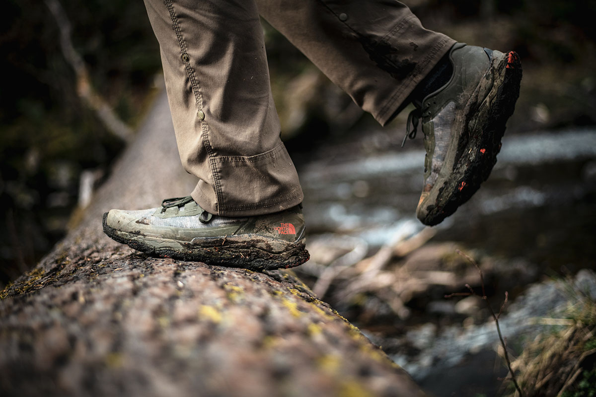 A pair of waterproof hiking shoes completely covered in thick brown mud.