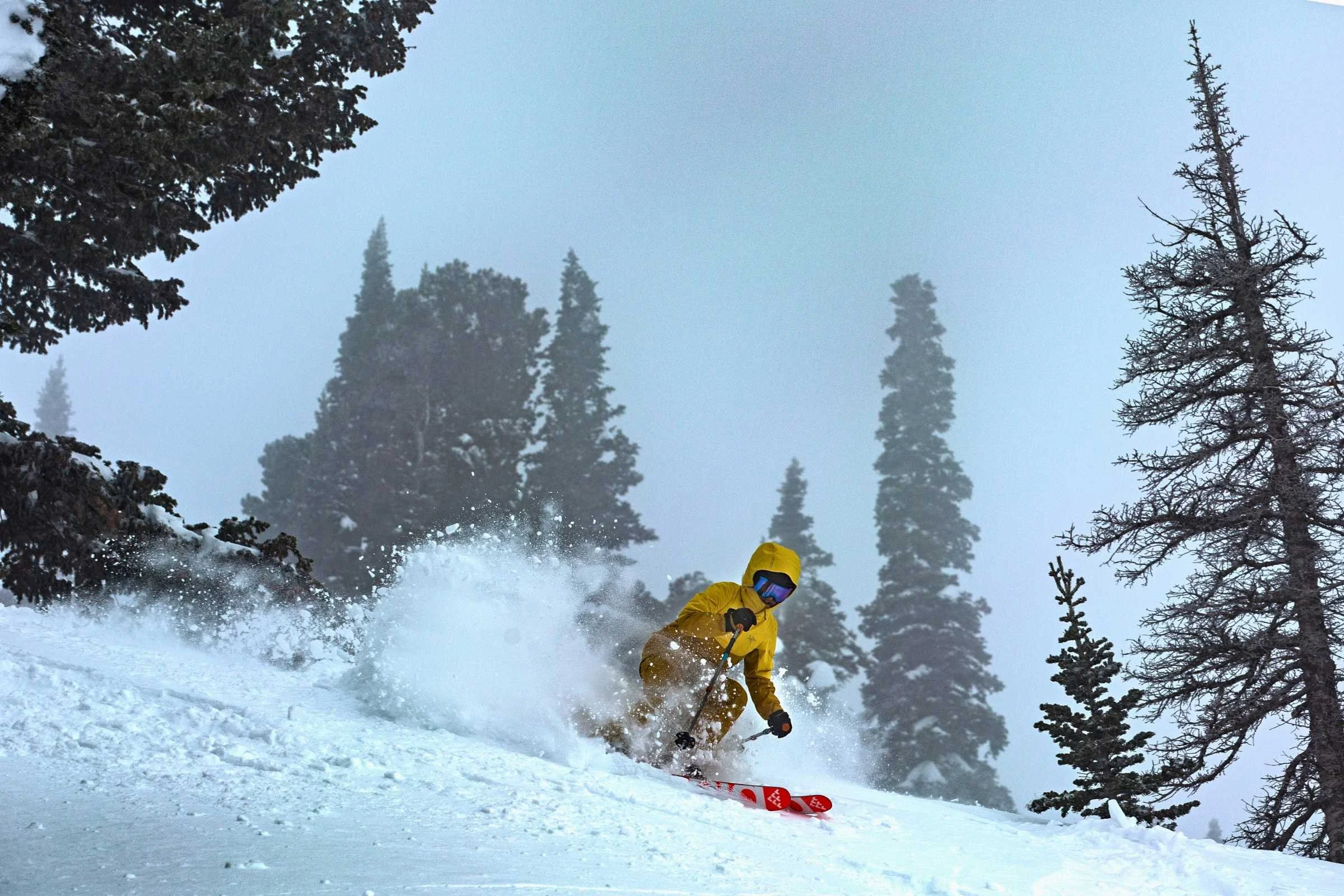 A skier wearing the Sentinel jacket in heavy snow at Snowbasin Resort in Utah.