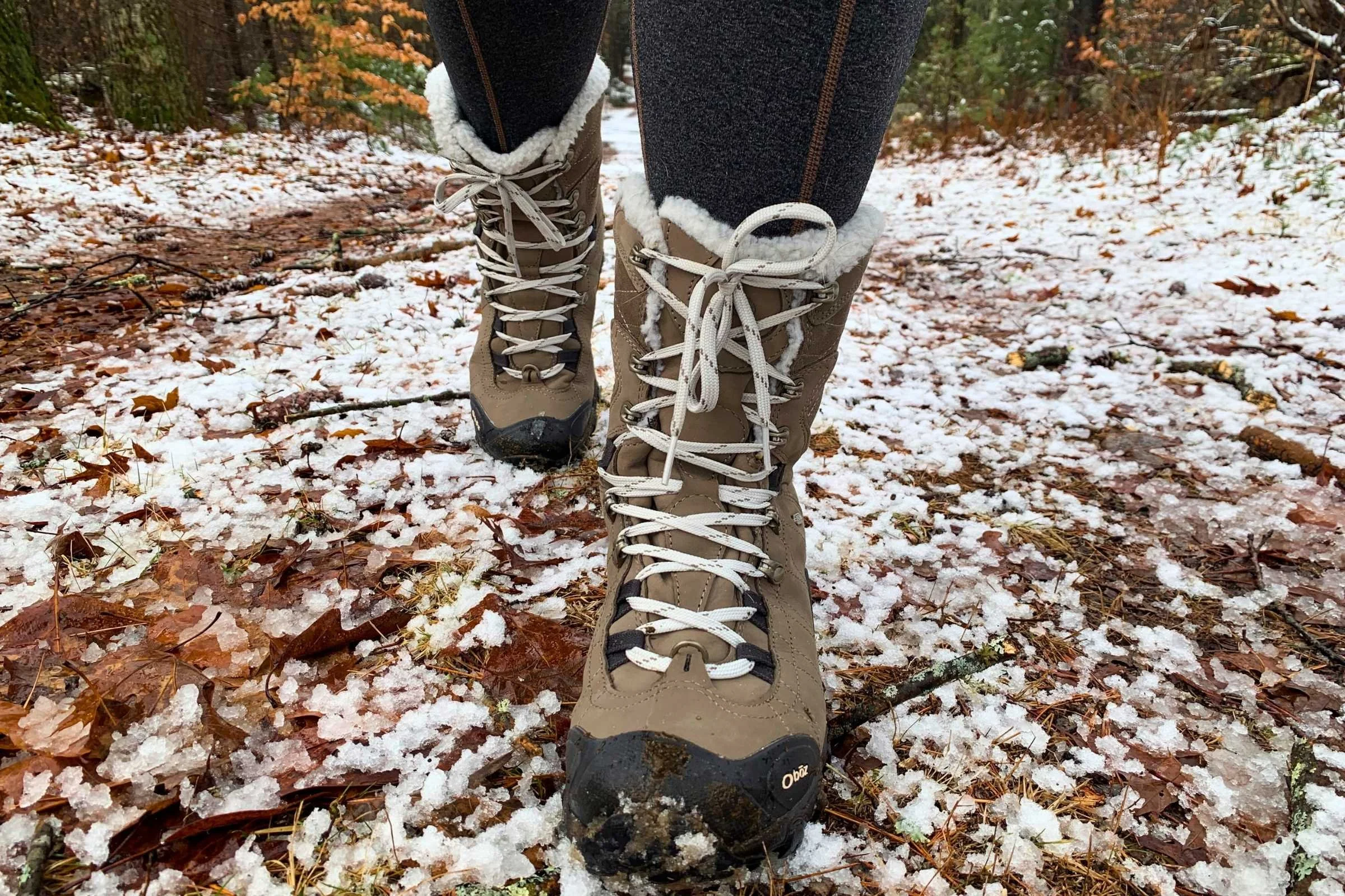 A pair of Oboz Bridger insulated winter hiking boots on a rocky, snow-covered trail.