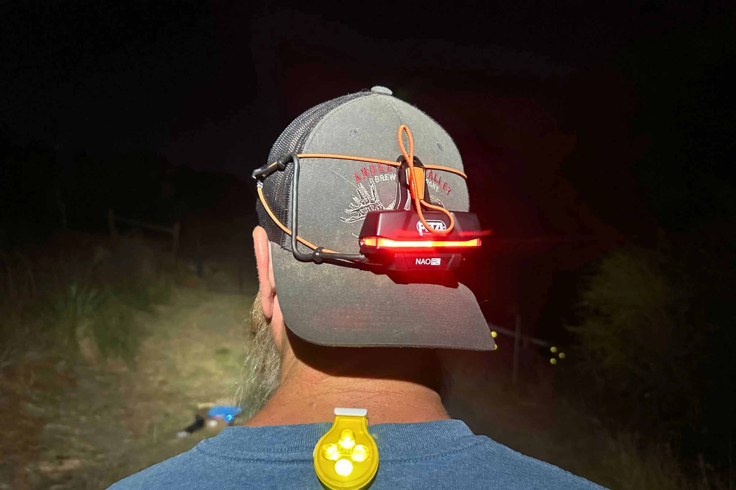 Close-up of a runner using a Nathan HyperBrite strobe and Petzl NAO RL rear light combination.