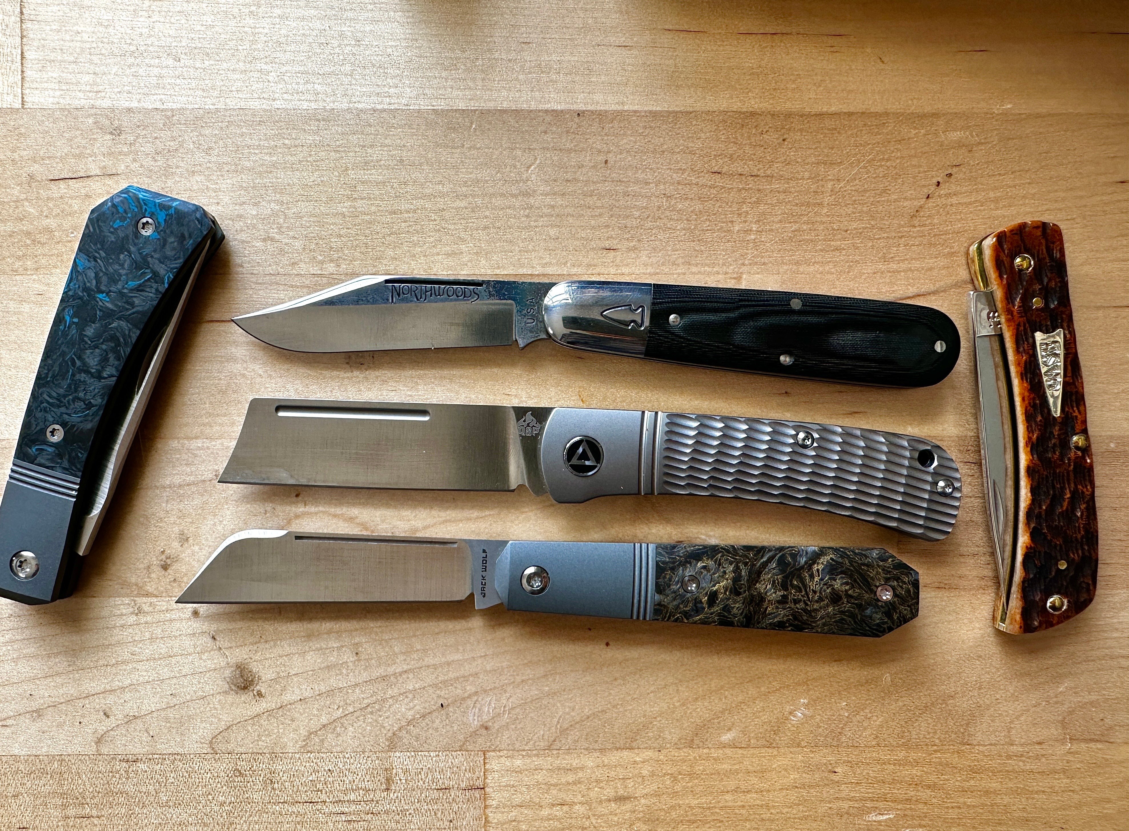 Four traditional style slipjoint pocket knives with textured handles.