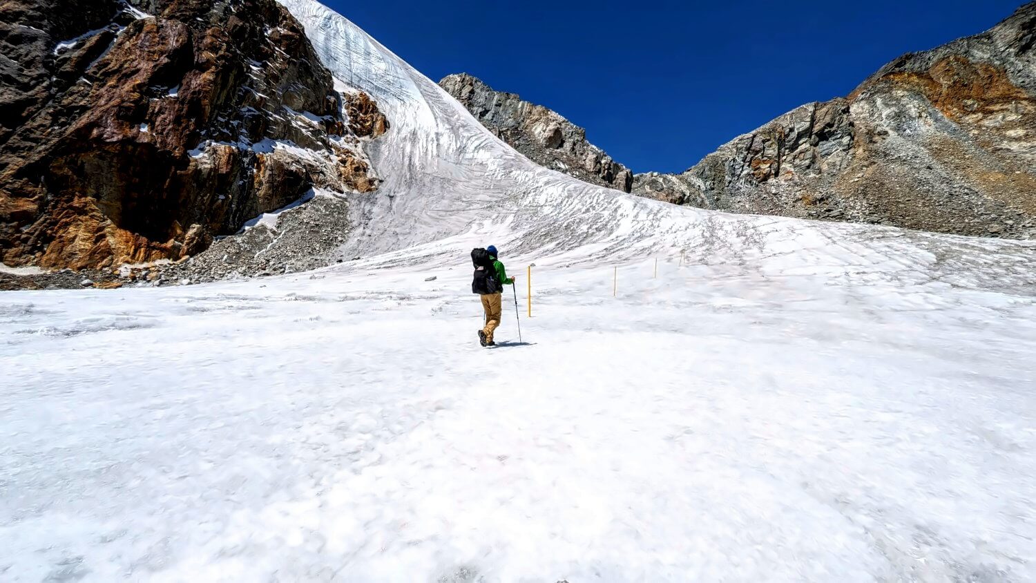 Trekkers carefully navigating across the icy surface of the Cho La glacier.
