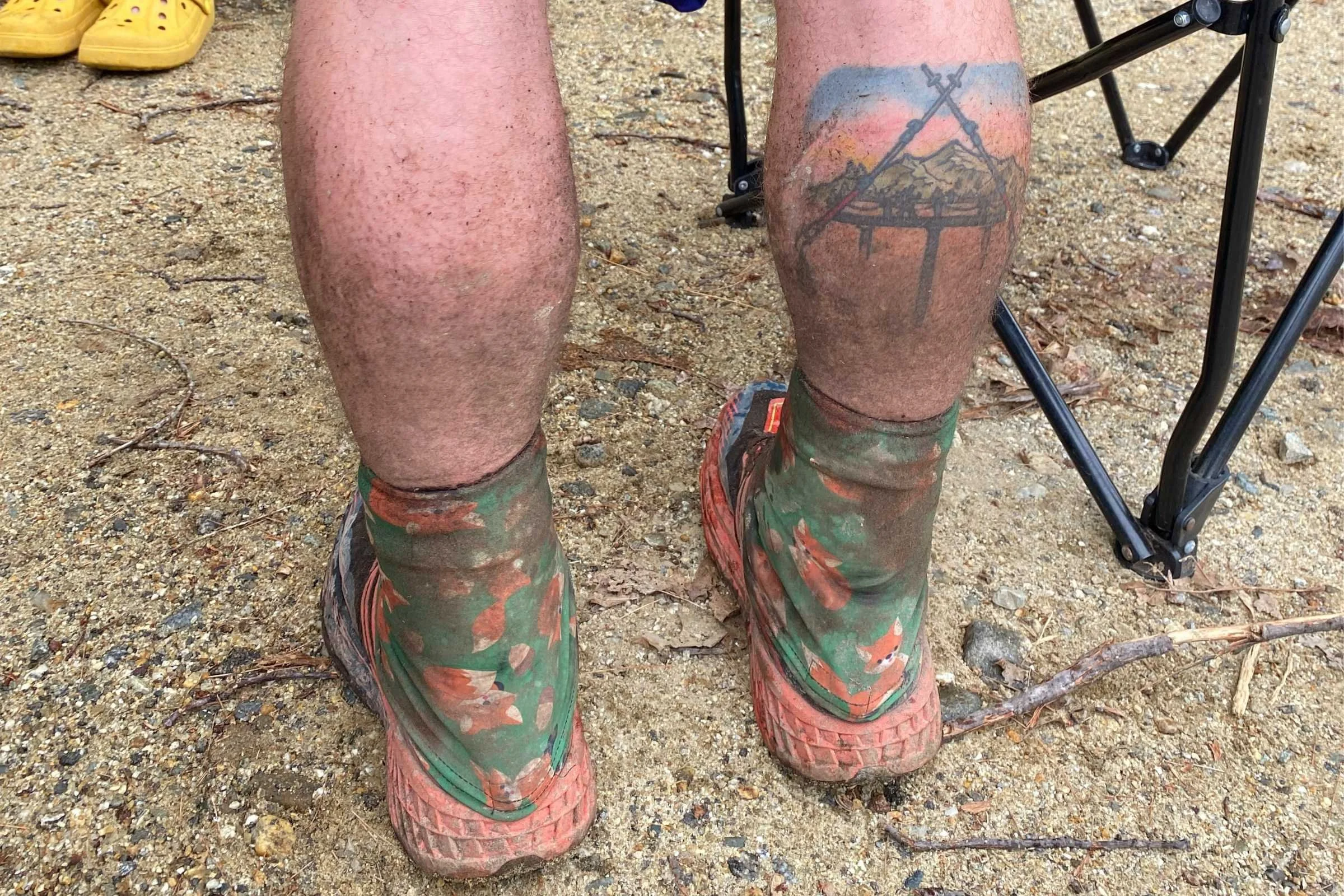 Patterned Dirty Girl gaiters worn over trail running shoes, covered in trail dust after a 100-mile race.
