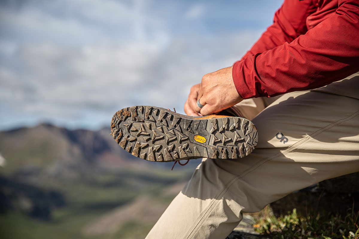 Close-up of the bottom sole of a hiking boot showing deep traction lugs and the Vibram logo.