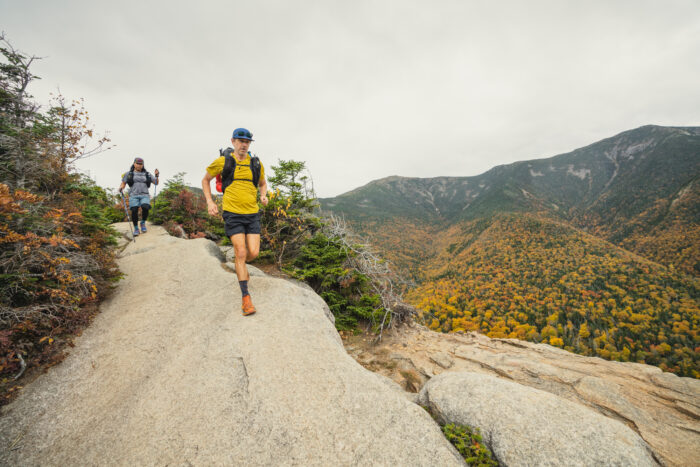 A runner navigating a technical mountain trail wearing performance compression shorts.