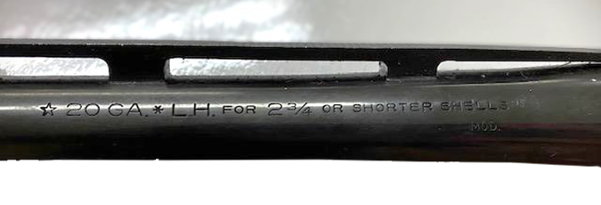 Detailed close-up of proof house stamps and markings on the underside of a shotgun barrel.