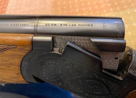 A view down the muzzle or breech of an over-under shotgun showing fixed chokes.